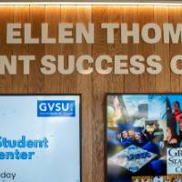 "Bob & Ellen Thompson Student Success Center" on wall, above two TV displays that show new success center hours